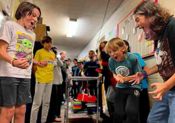 Children at private school with small classes yell and laugh when object falls correctly as part of project based learning.