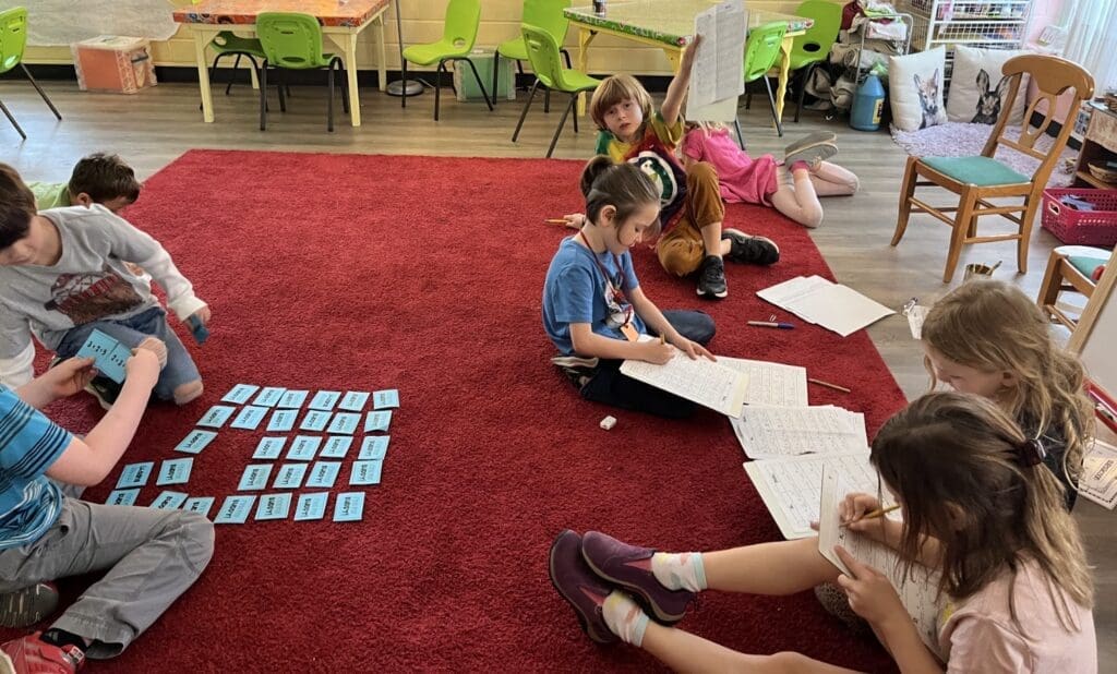 Students learn math on floor at alternative school.